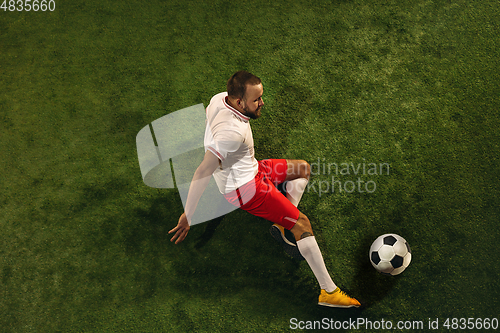 Image of Top view of caucasian football or soccer player on green background of grass