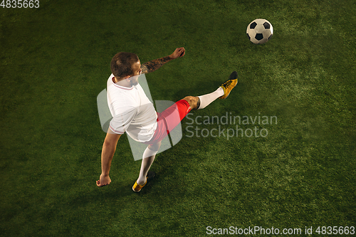 Image of Top view of caucasian football or soccer player on green background of grass