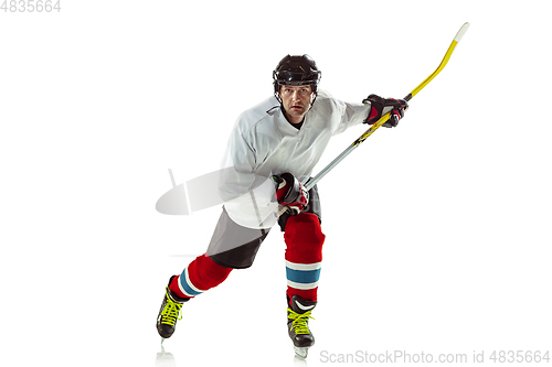 Image of Young male hockey player with the stick on ice court and white background