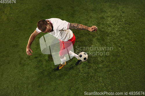 Image of Top view of caucasian football or soccer player on green background of grass