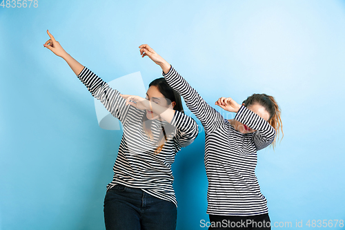 Image of Young emotional women on gradient blue background