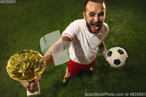 Image of Top view of caucasian football or soccer player on green background of grass