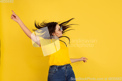 Image of Caucasian woman\'s portrait isolated on yellow studio background
