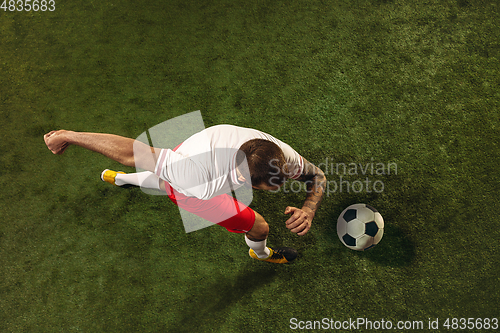 Image of Top view of caucasian football or soccer player on green background of grass