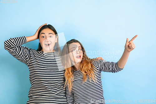 Image of Young emotional women on gradient blue background