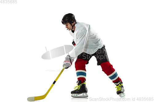 Image of Young male hockey player with the stick on ice court and white background