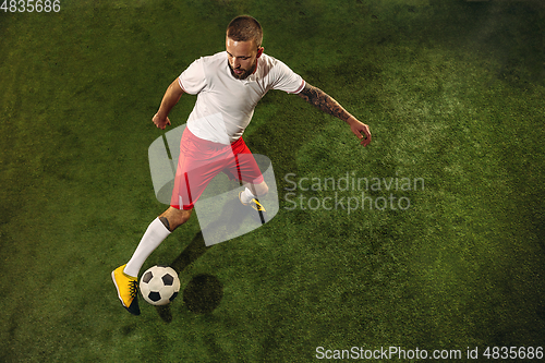 Image of Top view of caucasian football or soccer player on green background of grass