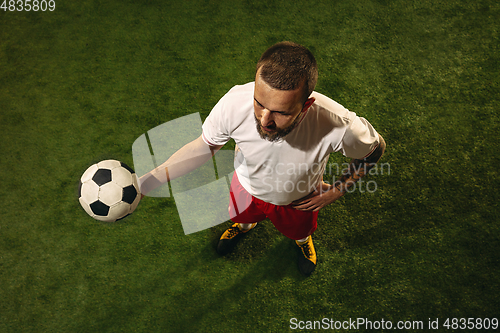 Image of Top view of caucasian football or soccer player on green background of grass