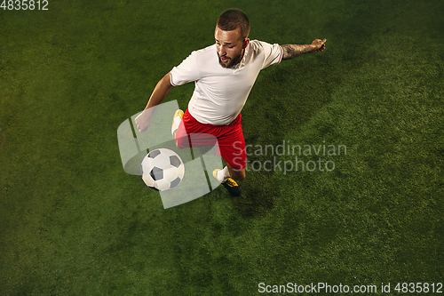 Image of Top view of caucasian football or soccer player on green background of grass