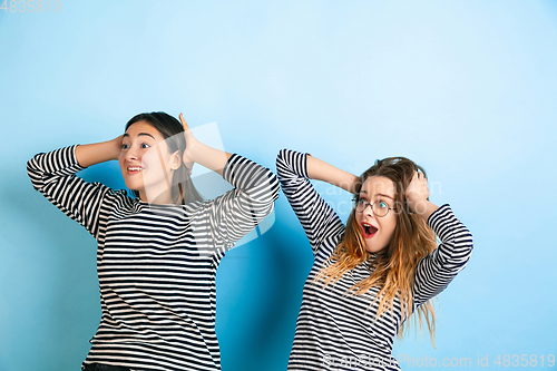 Image of Young emotional women on gradient blue background