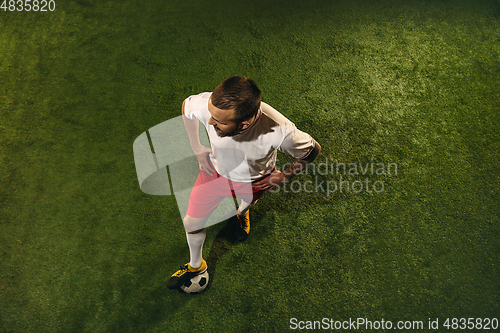 Image of Top view of caucasian football or soccer player on green background of grass