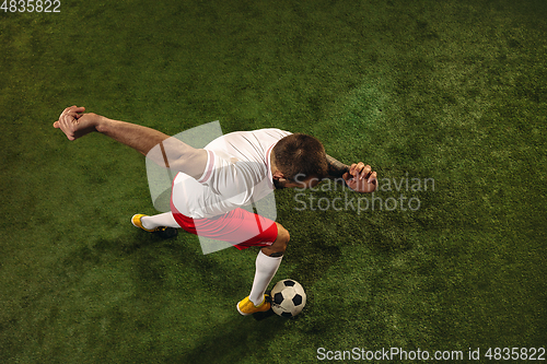 Image of Top view of caucasian football or soccer player on green background of grass