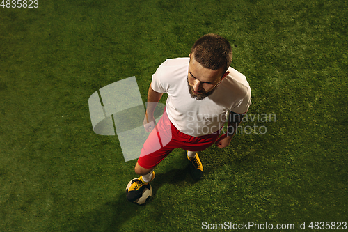 Image of Top view of caucasian football or soccer player on green background of grass