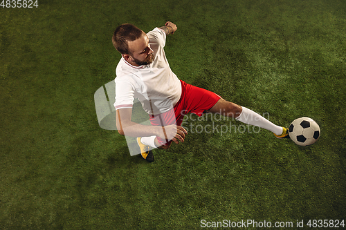 Image of Top view of caucasian football or soccer player on green background of grass