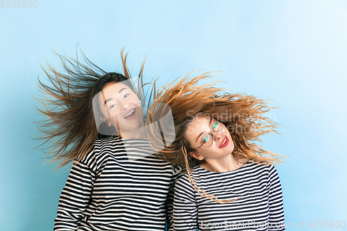 Image of Young emotional women on gradient blue background