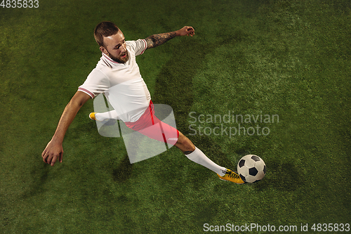 Image of Top view of caucasian football or soccer player on green background of grass