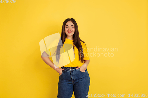 Image of Caucasian woman\'s portrait isolated on yellow studio background