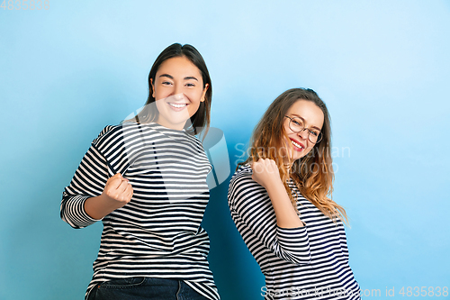 Image of Young emotional women on gradient blue background