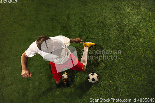 Image of Top view of caucasian football or soccer player on green background of grass