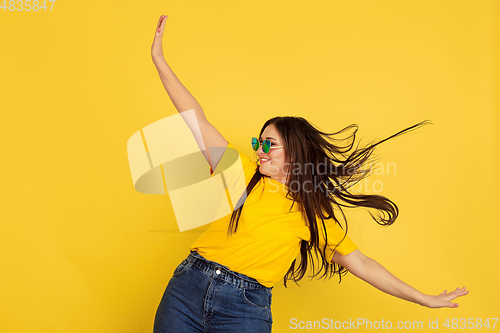 Image of Caucasian woman\'s portrait isolated on yellow studio background