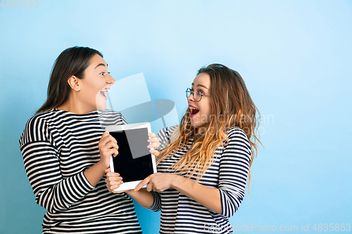 Image of Young emotional women on gradient blue background