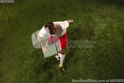 Image of Top view of caucasian football or soccer player on green background of grass