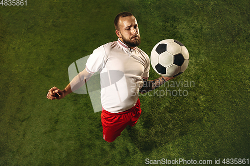 Image of Top view of caucasian football or soccer player on green background of grass