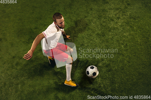 Image of Top view of caucasian football or soccer player on green background of grass