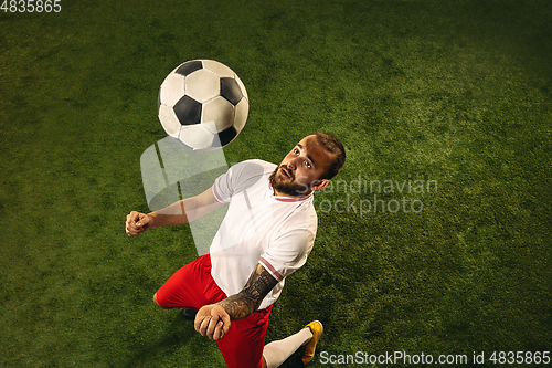 Image of Top view of caucasian football or soccer player on green background of grass