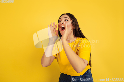 Image of Caucasian woman\'s portrait isolated on yellow studio background
