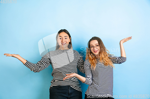 Image of Young emotional women on gradient blue background