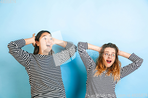 Image of Young emotional women on gradient blue background