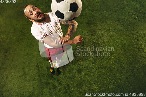 Image of Top view of caucasian football or soccer player on green background of grass