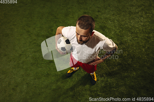 Image of Top view of caucasian football or soccer player on green background of grass