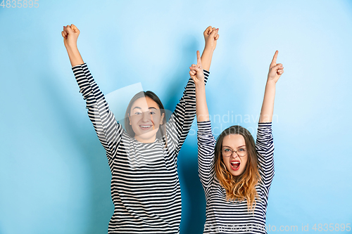 Image of Young emotional women on gradient blue background