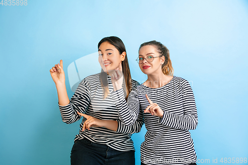 Image of Young emotional women on gradient blue background