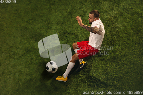 Image of Top view of caucasian football or soccer player on green background of grass