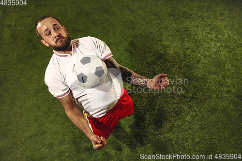 Image of Top view of caucasian football or soccer player on green background of grass