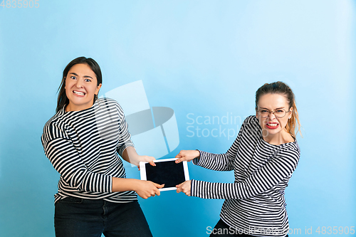 Image of Young emotional women on gradient blue background