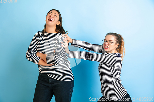 Image of Young emotional women on gradient blue background
