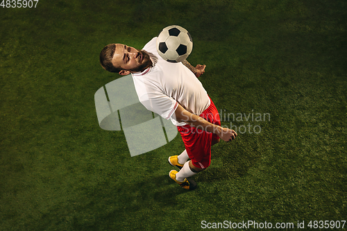 Image of Top view of caucasian football or soccer player on green background of grass