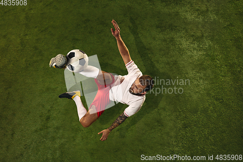 Image of Top view of caucasian football or soccer player on green background of grass