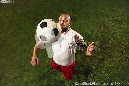 Image of Top view of caucasian football or soccer player on green background of grass
