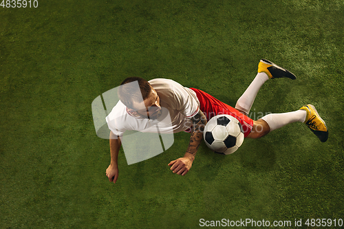 Image of Top view of caucasian football or soccer player on green background of grass