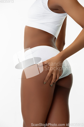 Image of Slim tanned woman\'s body isolated on white studio background