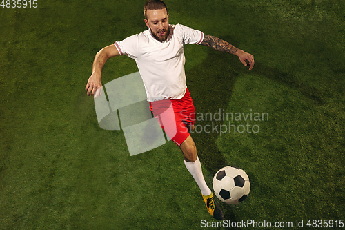 Image of Top view of caucasian football or soccer player on green background of grass