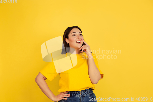 Image of Caucasian woman\'s portrait isolated on yellow studio background