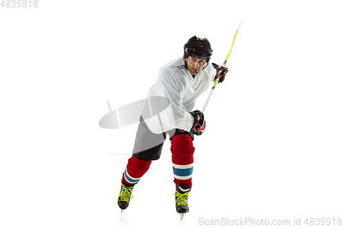 Image of Young male hockey player with the stick on ice court and white background