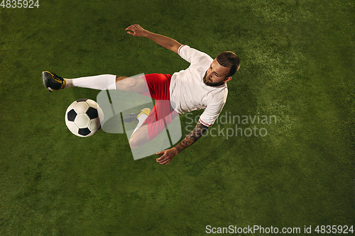 Image of Top view of caucasian football or soccer player on green background of grass