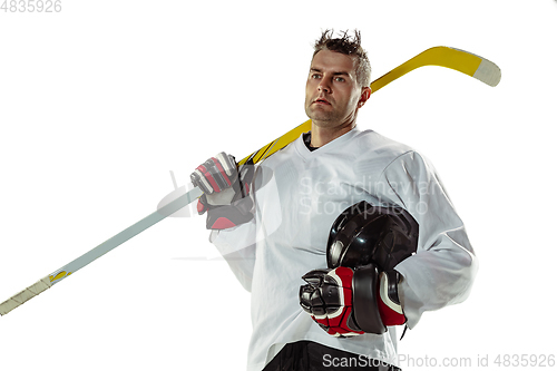 Image of Young male hockey player with the stick on ice court and white background